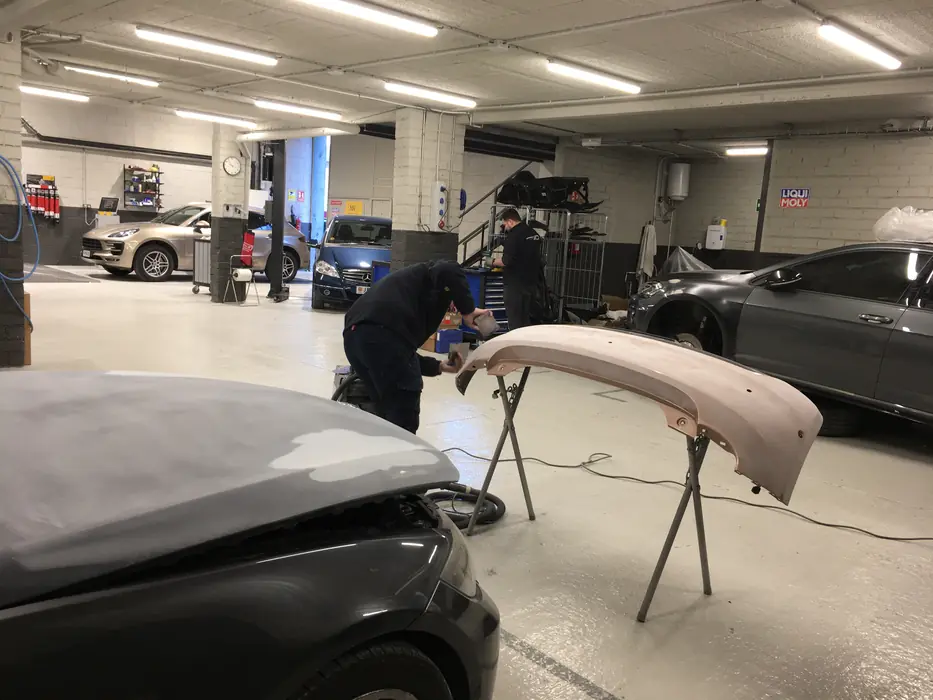 Un planxista prepara un para-xocs al taller